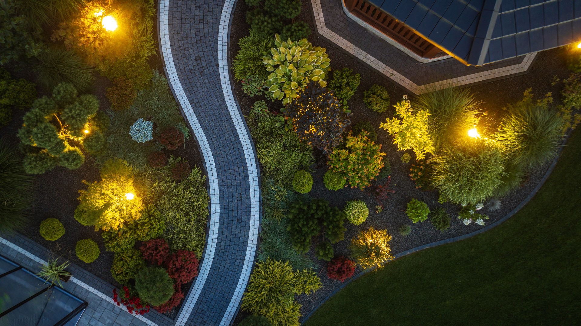 Winding Garden Path Illuminated by Warm Lights at Dusk